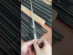 একজন মানুষ কার্বন ইস্পাত নল থেকে তৈরি একটি ছোট উপাদান প্রদর্শন করছে